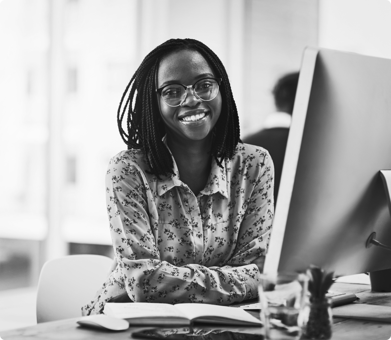 Person smiling and sitting at a computer