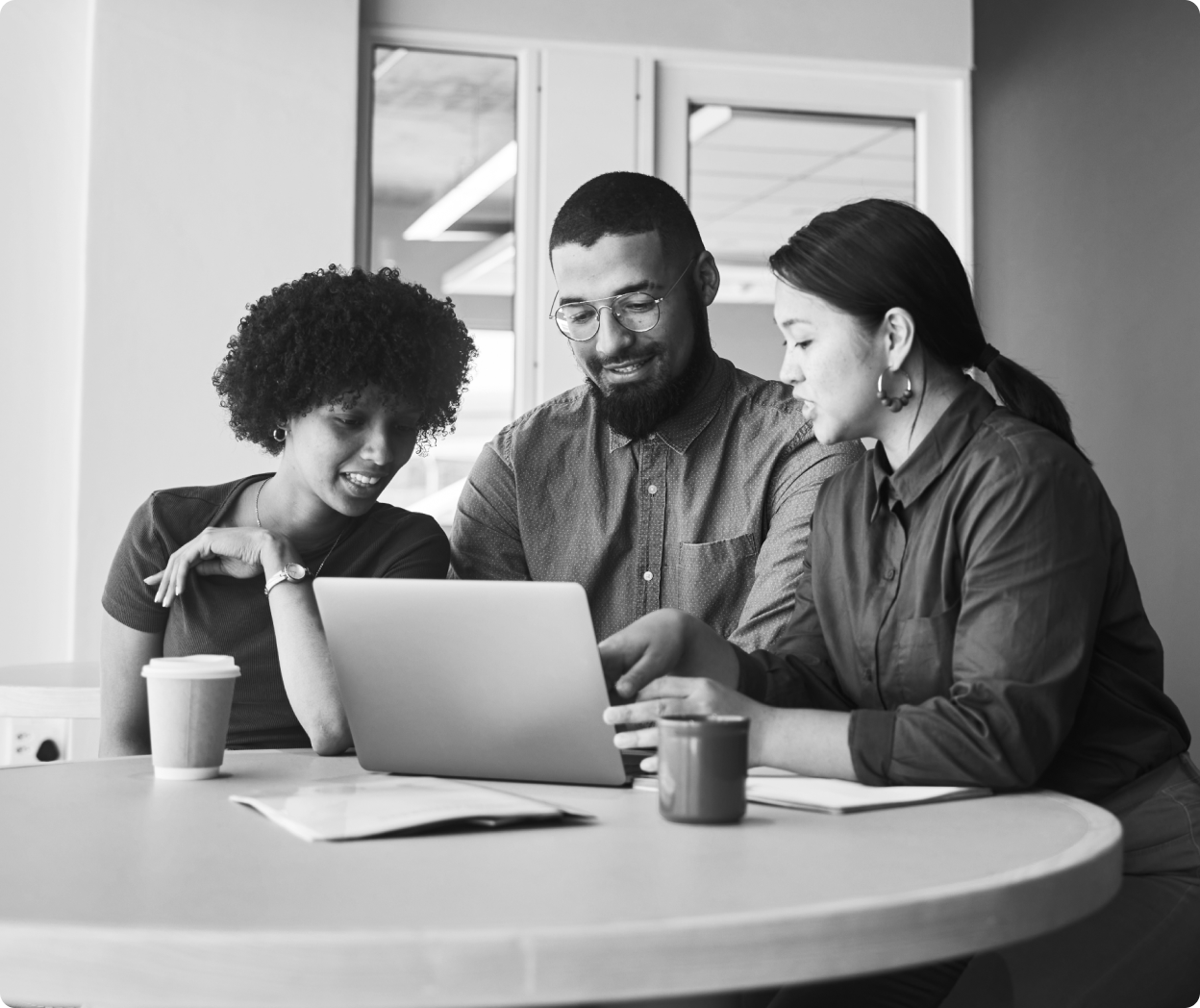 People sitting at table looking at laptop