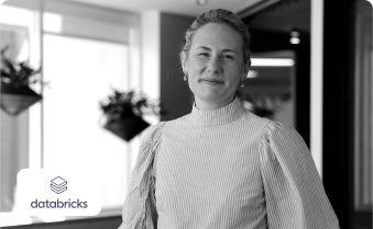 A woman stands beside the Databricks logo